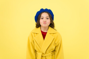 Duck face concept. Fashionable kid funny grimace face. Little fashionista posing. Kid funny face stand yellow background. Funny mimic expression. Kiss lips or funny duck face. Posing for camera
