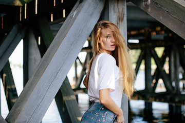 Cute amazing redhead girl posing under the bridge
