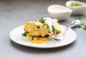 Potatoes casserole with cheese and green onion served with sour cream and mint. Vegetarian food. Copy space.