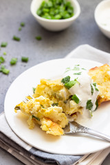 Potatoes casserole with cheese and green onion served with sour cream and mint. Vegetarian food. Copy space.