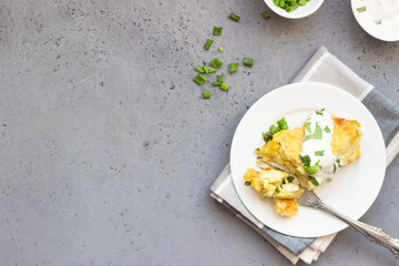 Potatoes casserole with cheese and green onion served with sour cream and mint. Vegetarian food. Copy space.