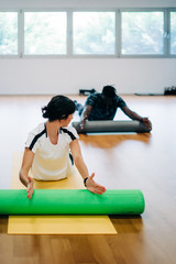 People doing exercises with foam rollers in the gym