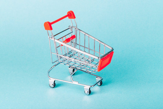 image of side view empty supermarket shopping cart on blue background