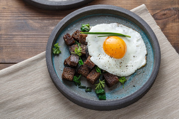 Breakfast with fried egg and croutons, close view copy space
