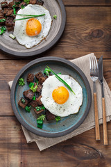Sunny side fried egg with croutons and herbs, close view