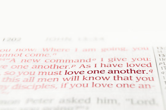 Bible text red letters reading love one another with copy space