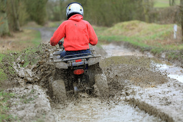 quad bike traveling along dirty countryside track © dean