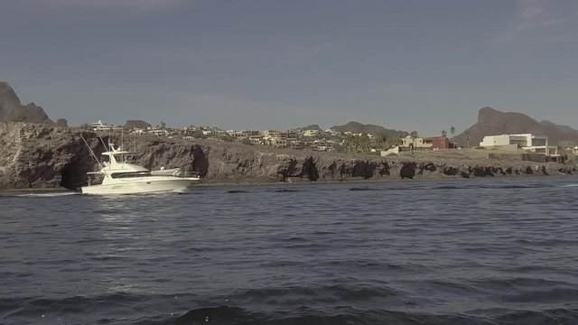 Slow motion gimbaled shot of yacht leaving San Carlos in Sea of Cortez.