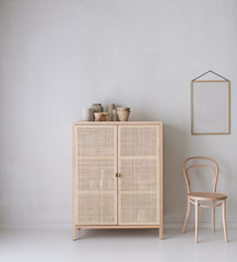 Raum mit Schrank und Stuhl und leerem Bilderrahmen