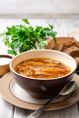 Traditional Russian sauerkraut soup Shchi in bowl on rustic wooden background. Selective focus.