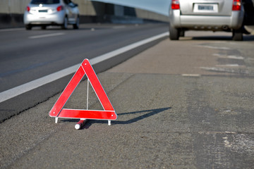 Closeup of warning triangle on roadside - obrazy, fototapety, plakaty
