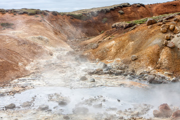 View of the hot, steam-emitting sulfuric salt springs in the crevice, Krysuvík, Iceland