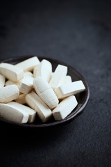 BCAA amino acids. Nutrition for bodybuilding. Fitness supplements on black stone background. Close up. Copy space. 