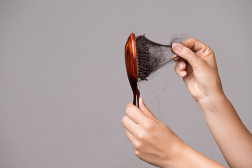 Healthcare concept. Woman show her brush with long loss hair and pulling her hair from brush. - obrazy, fototapety, plakaty