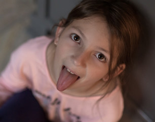 High angle view of young girl making a face at the camera