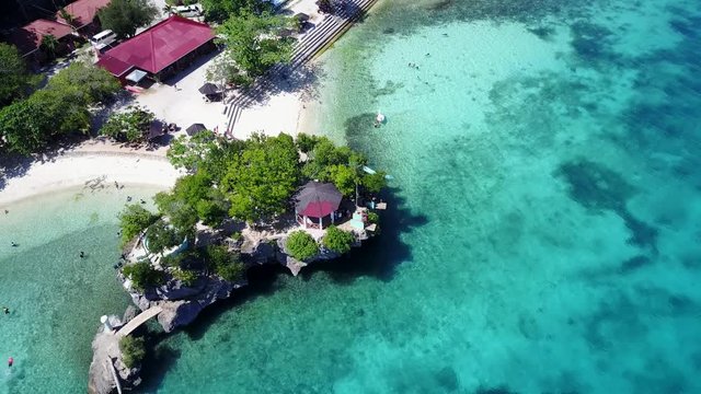 Small peninsula surrounded by crystal clear water and reef. Siquijor Salagdoong Beach, Philippines - 4k aerial footage.