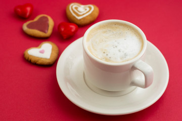 Love, Valentine's Day concept. Cup of coffee or latte and heart shaped cookies, biscuits. Red background, copy space.