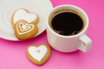 Cup of coffee and heart shaped cookies, biscuits. Valentine heart cookies. Top view. Pink background.