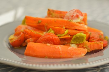 Fried, cooked carrots with green herbs, close up. Vegetarian food.