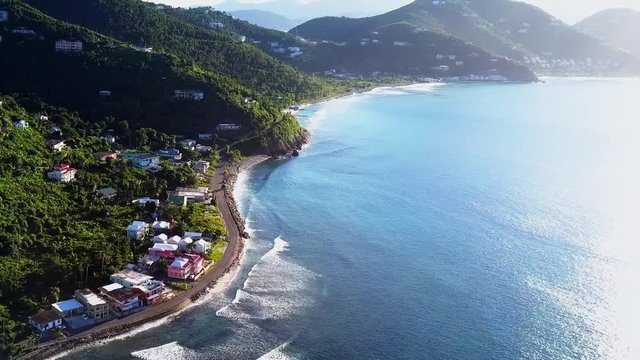 Aerial British Virgin Island Tortola beach fly by of local homes on the water angle 1