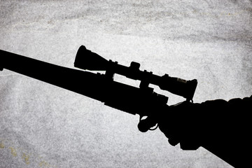 Bolt action carbine with an scope in the hand of a man. Long-range shotgun, conceptual photo. Place...