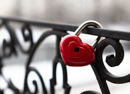 background. a red lock in the shape of a heart is hanging on the fence. Valentine's day holiday.