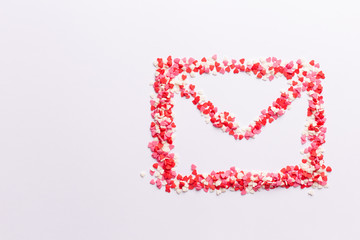 envelope shape on white background made of red white and pink hearts sweets. Top view. Valentine day. love concept. Gift, message for lover. Space for text