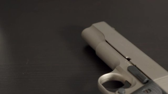 Panning over cocked pistol on table