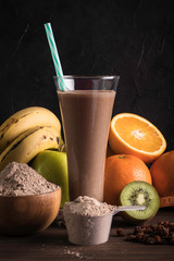 Chocolate protein shake with fruits and raisins on the wood table