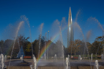 Fototapeta premium modern high skyscraper view from the park day, sun with rainbow