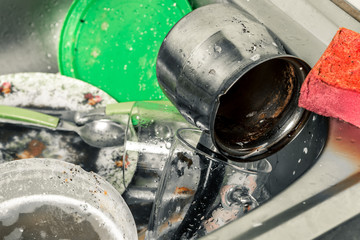 dirty dishes, cups, plates, spoons in the sink