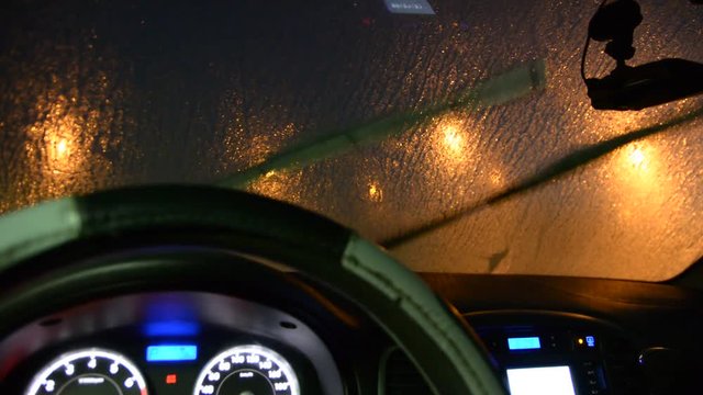 windscreen wiper can't remove ice from the windshield. view from inside of car night low light.