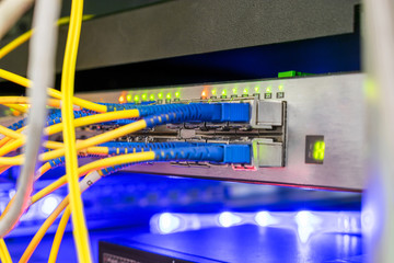 High-speed Internet connection of fiber optic wires with modular interfacing switch. The silver equipment of a modern data center. Selective focus
