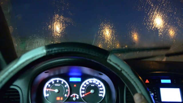 windscreen wiper can't remove ice from the windshield. view from inside of car night low light.