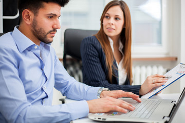 Obraz premium Two young business partners discussing plans or ideas at meeting