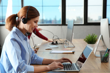 Technical support operator with headset at workplace