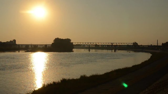 Golden sunset over the river. Peaceful sunset over river Sava in Brod, Croatia. View of the beautiful golden sunset in summer. Bridge on Sava river 