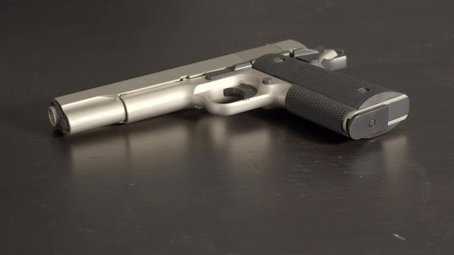 Cocked pistol on table, still shot