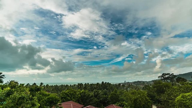 Storm wind with clouds over a tropical island and rooftops. 4k time lapse

