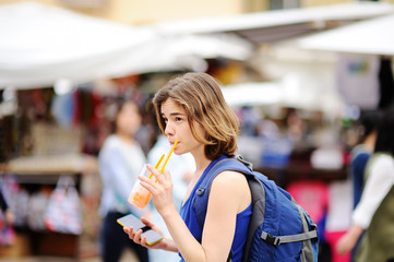 Cheerful girl drinks juice on the street of Rome