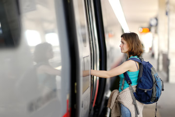 Fototapeta na wymiar Young woman with backpack take the train.