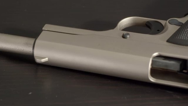Panning back and forth over barrel of open and empty pistol.