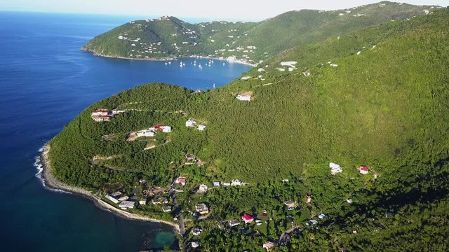 Aerial drone fly in to a large cliffside home on British Virgin Island of Tortola distant shot.