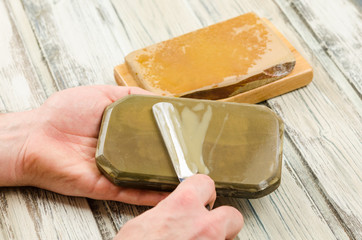 Water sharpening stones and cutthroat razor. Razor and sharpening stones on a rustic background. Sharpening razor with whetstone. Close up of hands sharpening razor.