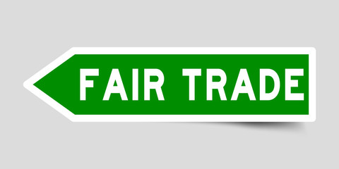 Arrow shape green color sticker in word fair trade on gray background