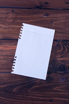 Folha de caderno com o fundo de madeira