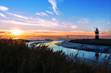 Leuchtturm in Wremen bei Bremerhaven im Sonnenuntergang, Weltnaturerbe Wattenmeer in...
