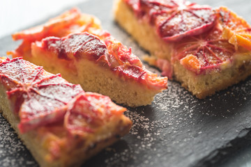 Drei Stücke von einem Blutorangenkuchen mit Puderzucker