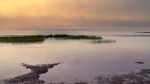 Sunset on Cape Cod&permil;&Ucirc;&ordf;s western shore with marshlands and foggy low cloud cover