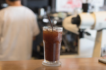Iced Americano coffee.Background with coffee machine and barista.